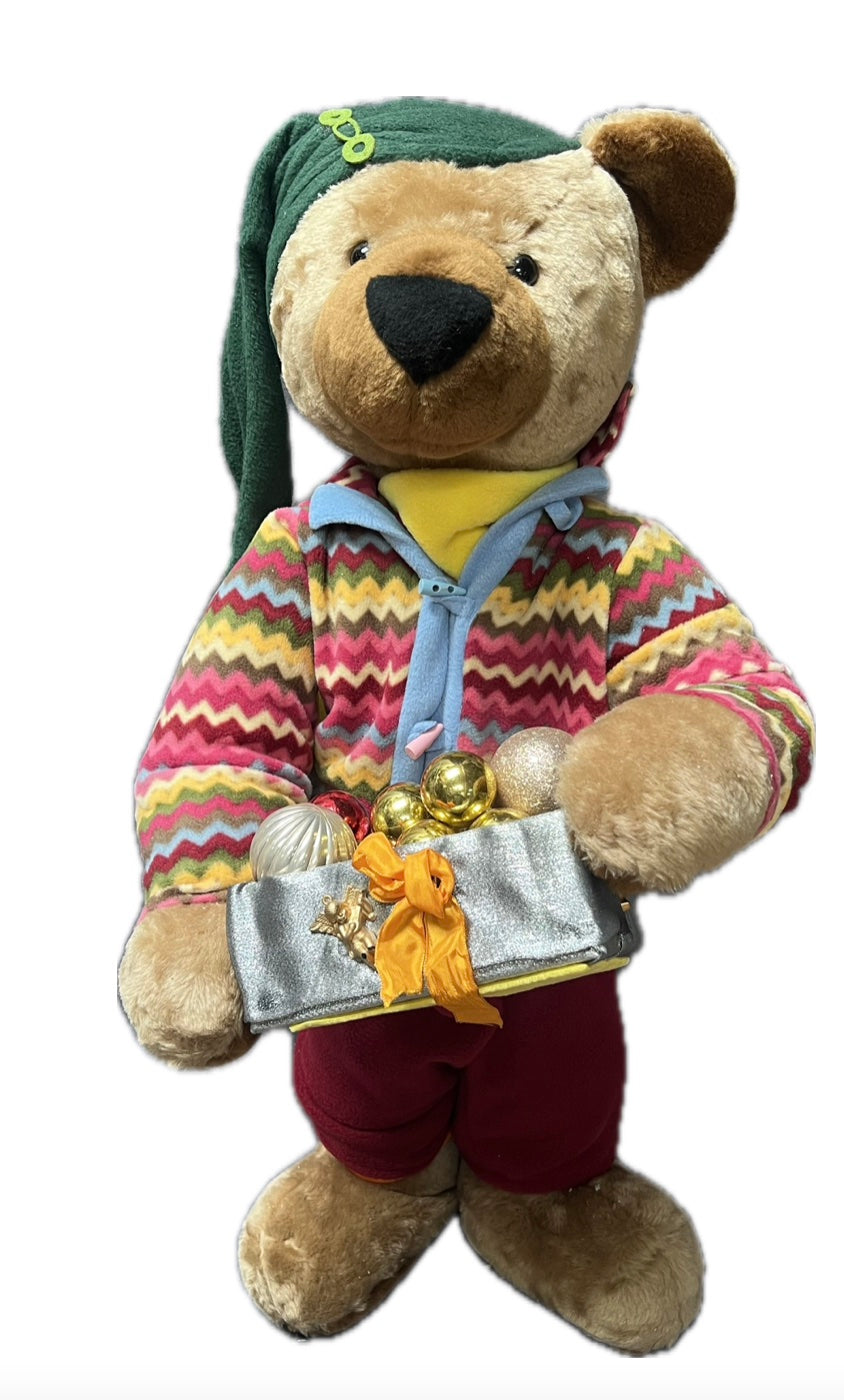 Teddy bear with green hat and gift package with balls 