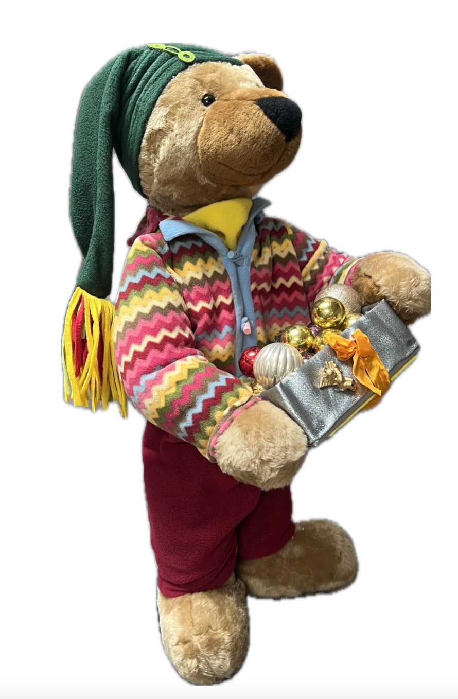 Teddy bear with green hat and gift package with balls 