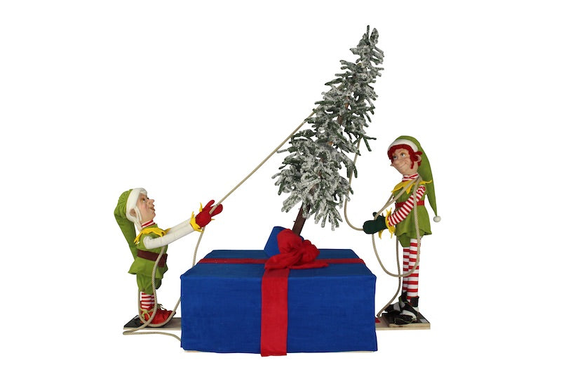 Christmas elves erect a tree. 