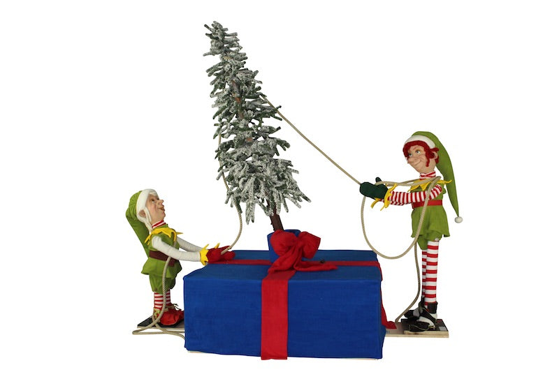 Christmas elves erect a tree. 