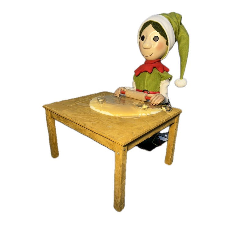 Elf with button eyes rolls out dough (Christmas bakery) 