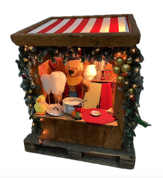 Decorative market stall selling cotton candy with a teddy bear as operator